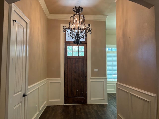 entryway with ornamental molding, dark hardwood / wood-style floors, and a notable chandelier