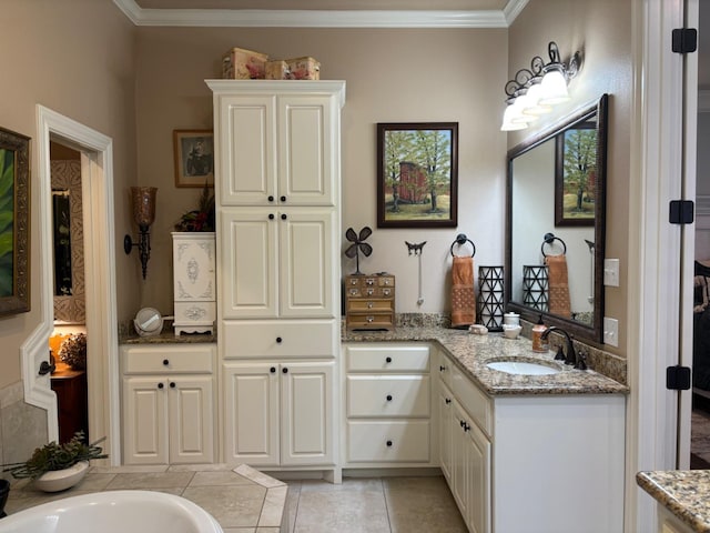 bathroom featuring ornamental molding, a tub, vanity, and tile patterned floors