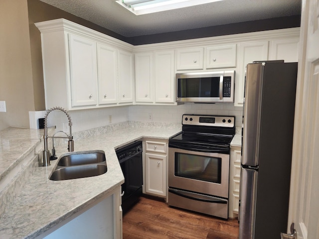 kitchen featuring white cabinetry, appliances with stainless steel finishes, dark wood-style flooring, and a sink