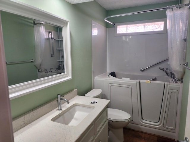 full bath with toilet, bathtub / shower combination, wood finished floors, and vanity