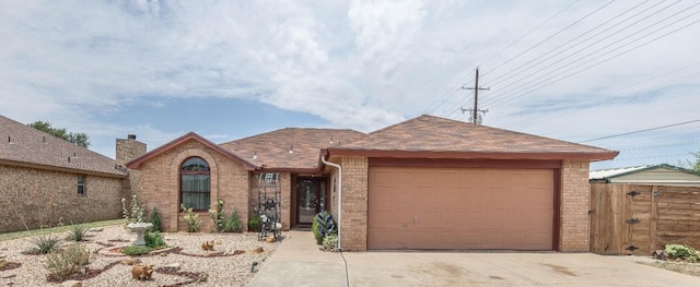 ranch-style home with a garage, driveway, brick siding, and a shingled roof