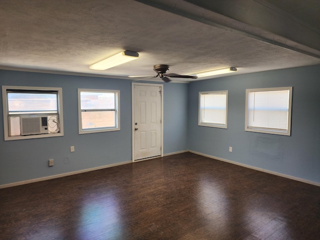 unfurnished room with ceiling fan, a textured ceiling, baseboards, and dark wood-type flooring