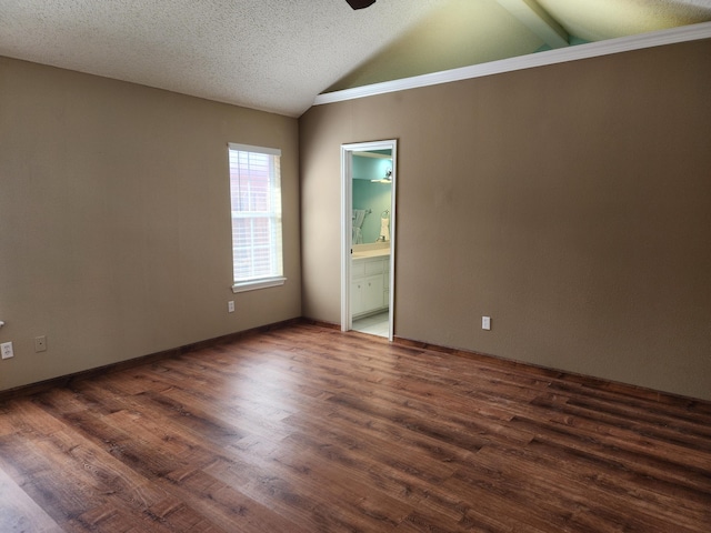 empty room featuring vaulted ceiling, dark wood-style flooring, a textured ceiling, and a ceiling fan