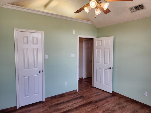 unfurnished bedroom featuring vaulted ceiling with beams, a textured ceiling, dark wood-type flooring, visible vents, and baseboards