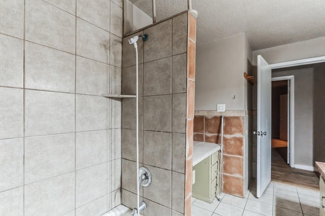 bathroom featuring tile patterned flooring, tile walls, and a textured ceiling