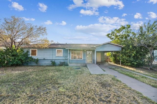 ranch-style house featuring a carport and a front lawn