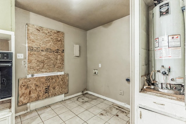 laundry room with washer hookup, water heater, and light tile patterned floors