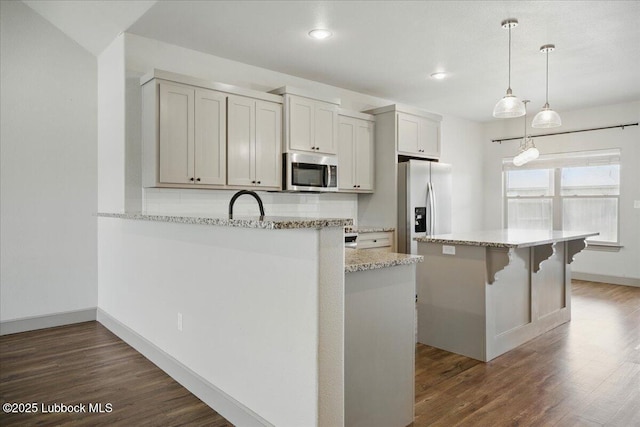 10330 Ave X Ave, Lubbock, TX 79423 - kitchen with appliances with stainless steel finishes, dark wood-style floors, recessed lighting, light stone countertops, and pendant lighting