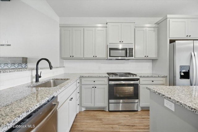 10330 Ave X Ave, Lubbock, TX 79423 - kitchen with appliances with stainless steel finishes, light stone countertops, light wood finished floors, and tasteful backsplash
