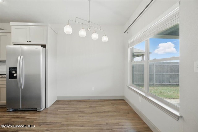 10330 Ave X Ave, Lubbock, TX 79423 - kitchen featuring stainless steel refrigerator with ice dispenser, wood finished floors, decorative light fixtures, and white cabinetry