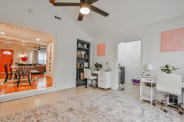 office space with vaulted ceiling, built in desk, built in features, light tile patterned floors, and ceiling fan