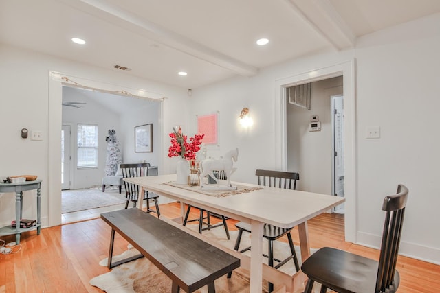 dining room with beam ceiling and light wood-type flooring