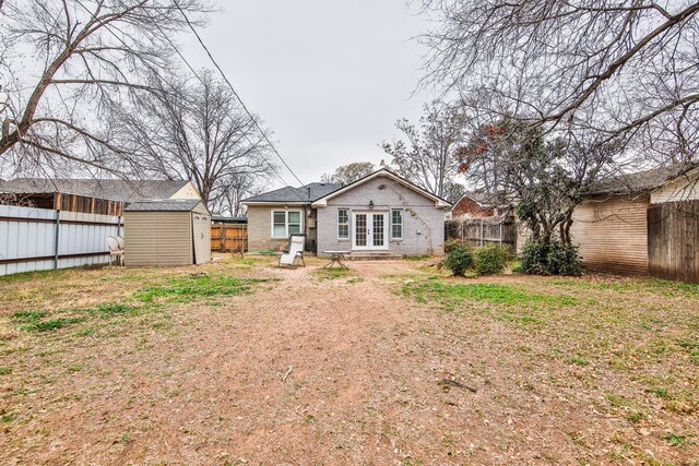 rear view of house featuring a storage unit and a lawn