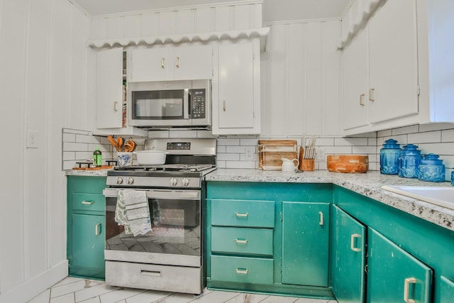 kitchen featuring white cabinets, appliances with stainless steel finishes, and backsplash