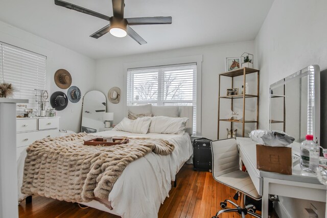 bedroom with dark hardwood / wood-style floors and ceiling fan