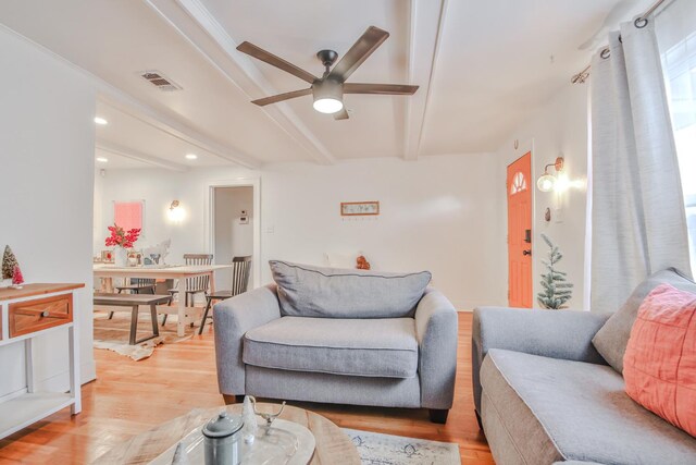 living room with ceiling fan, beam ceiling, and light hardwood / wood-style flooring