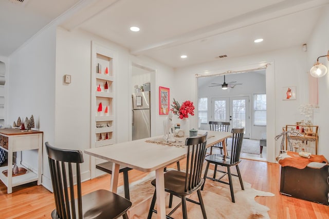 dining area with built in features, ceiling fan, light hardwood / wood-style floors, beam ceiling, and french doors