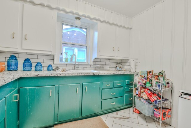 kitchen with sink, white cabinets, and decorative backsplash