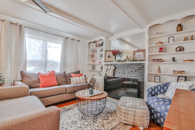 living room with hardwood / wood-style flooring, a fireplace, beam ceiling, and built in shelves