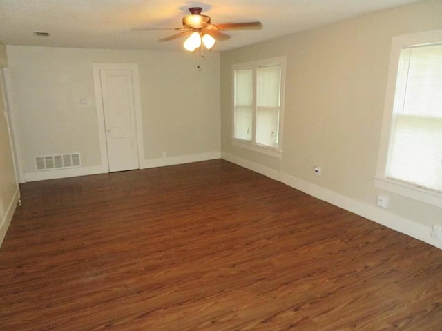 unfurnished room featuring dark wood-type flooring and ceiling fan