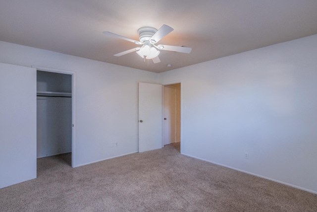 unfurnished bedroom featuring ceiling fan, light carpet, and a closet