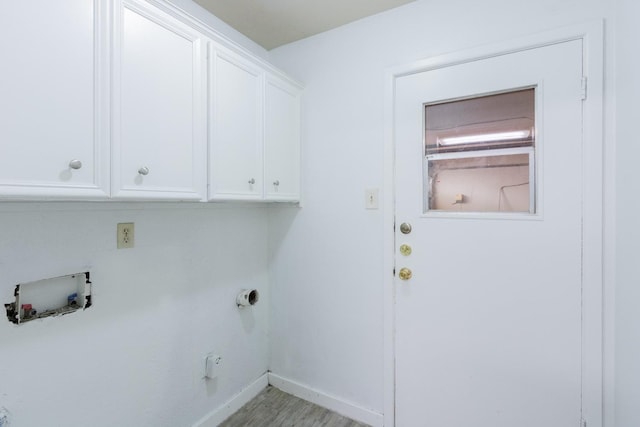 laundry area with hookup for a washing machine, light hardwood / wood-style flooring, and cabinets