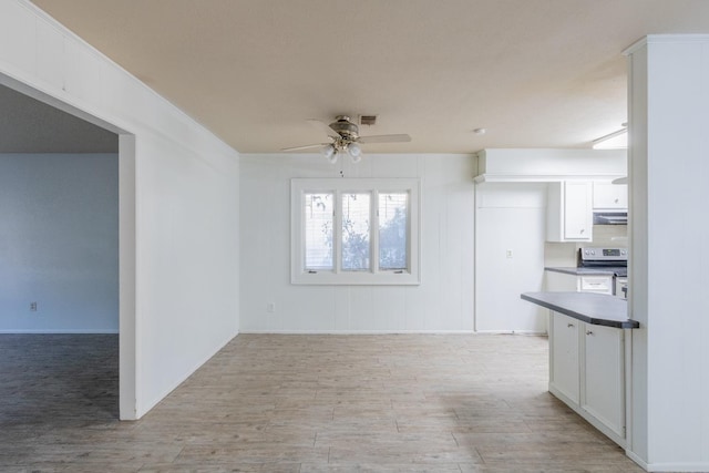 kitchen featuring ceiling fan, stainless steel range with electric stovetop, extractor fan, and white cabinets