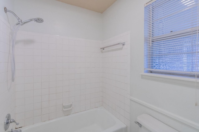 bathroom featuring toilet and tiled shower / bath combo