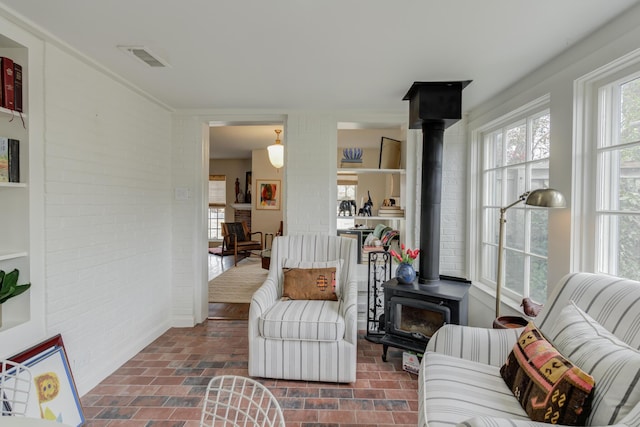 3003 19th St, Lubbock, TX 79410 - living area featuring a wood stove, plenty of natural light, and brick floors