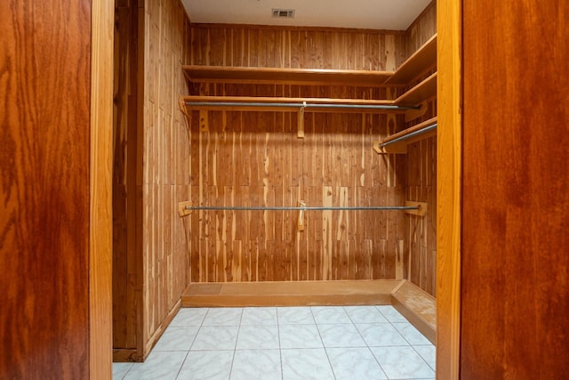 walk in closet with light tile patterned floors