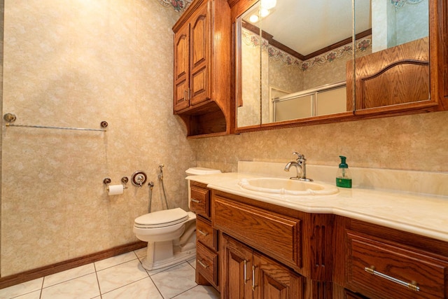 bathroom with a shower with shower door, vanity, ornamental molding, toilet, and tile patterned floors