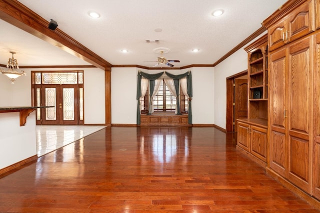 empty room with dark hardwood / wood-style flooring, crown molding, french doors, and ceiling fan