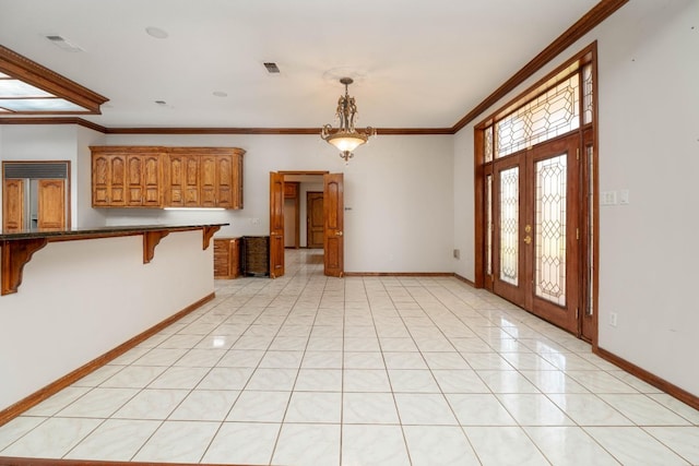 interior space featuring french doors, ornamental molding, and light tile patterned floors