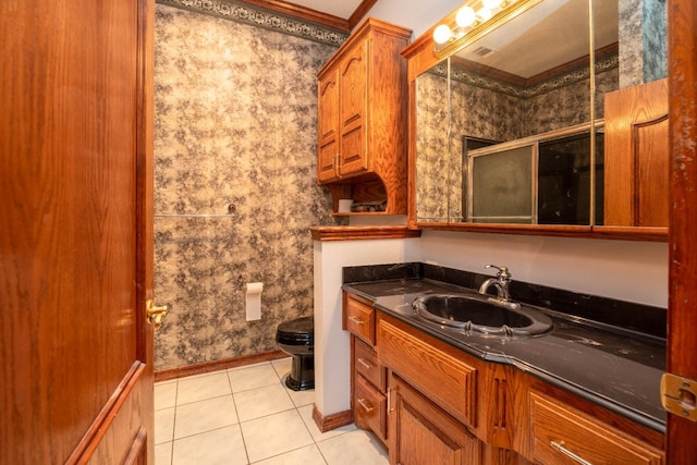 bathroom featuring tile patterned floors, toilet, crown molding, vanity, and a shower with door