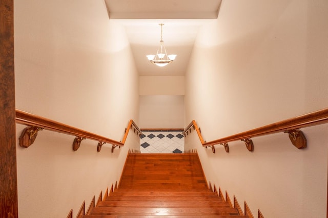 stairs featuring a chandelier