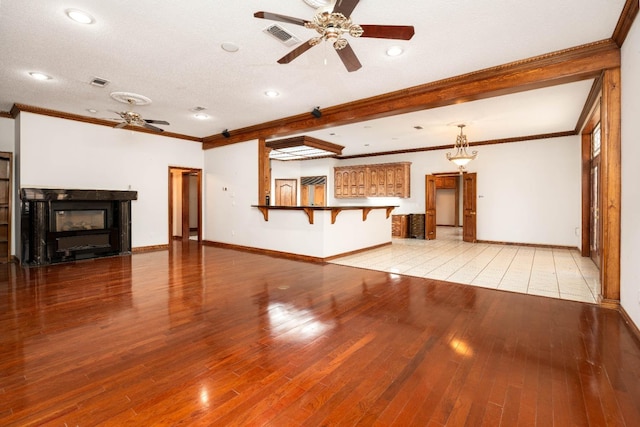 unfurnished living room with ornamental molding, light hardwood / wood-style floors, and ceiling fan