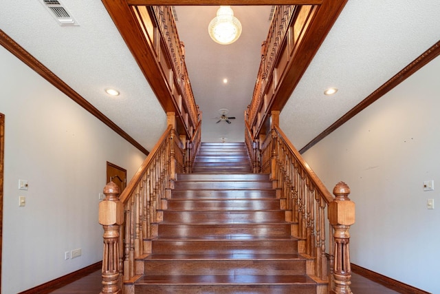 staircase featuring ornamental molding, wood-type flooring, and a textured ceiling