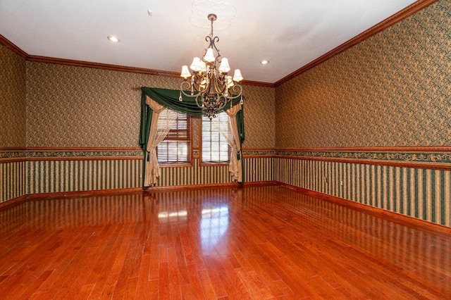 unfurnished room with a notable chandelier, wood-type flooring, and ornamental molding