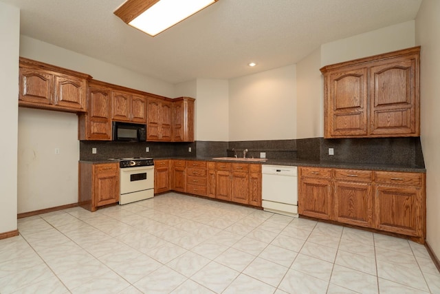 kitchen featuring tasteful backsplash, white appliances, and sink