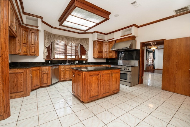 kitchen featuring a center island, light tile patterned floors, ornamental molding, appliances with stainless steel finishes, and wall chimney range hood