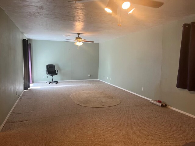 empty room with ceiling fan, a textured ceiling, and carpet