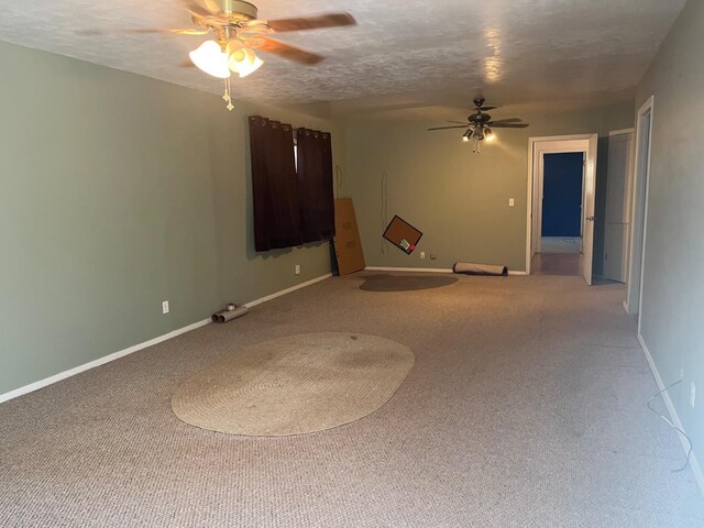 carpeted empty room featuring ceiling fan and a textured ceiling