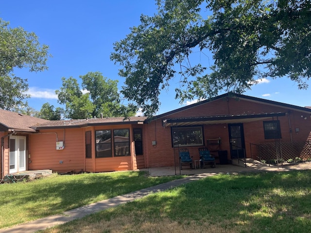 rear view of property with a lawn and a patio area