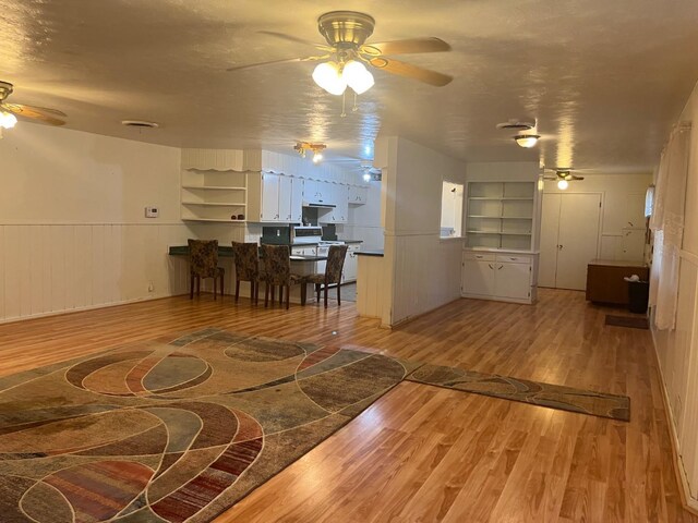 living room featuring hardwood / wood-style floors, a textured ceiling, and ceiling fan