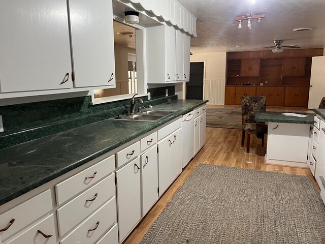 kitchen featuring sink, dishwasher, ceiling fan, white cabinetry, and light hardwood / wood-style floors