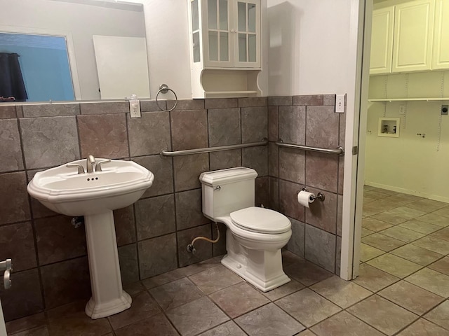 bathroom featuring tile walls, tile patterned flooring, and toilet