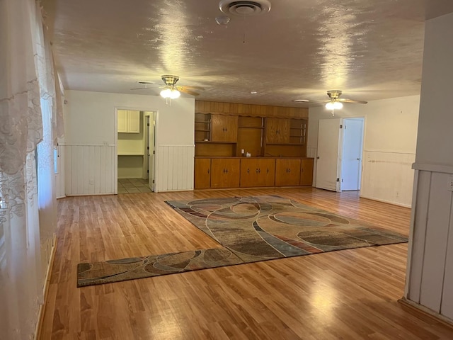 unfurnished living room featuring ceiling fan and hardwood / wood-style floors