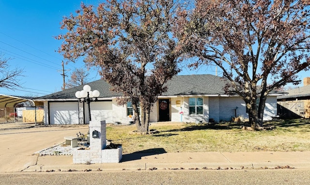 ranch-style home with a garage, a front yard, and a carport