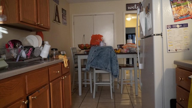 kitchen featuring white refrigerator and light tile patterned floors