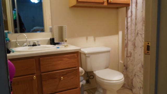 bathroom featuring vanity, curtained shower, and toilet